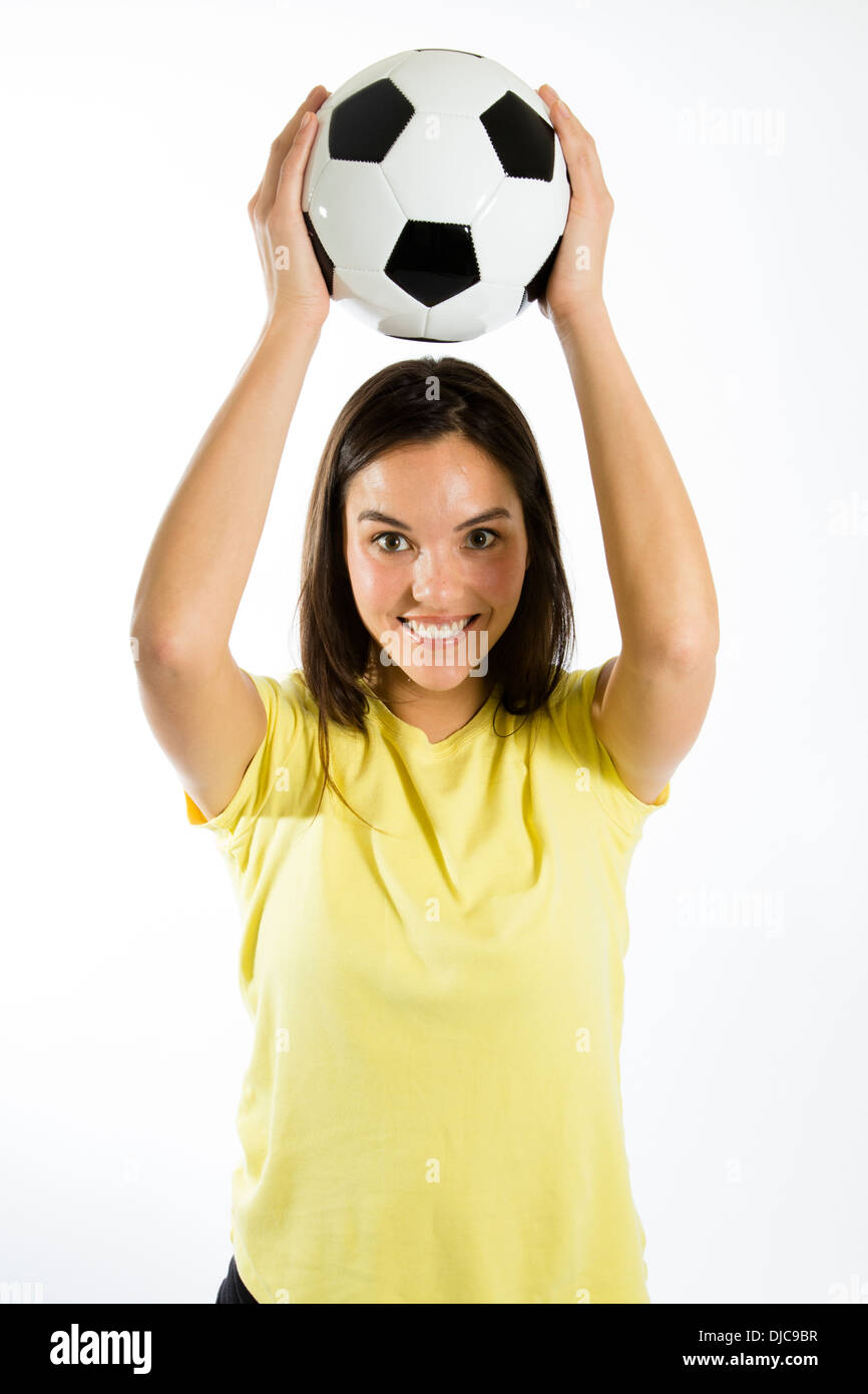 Giovane atleta femminile tenendo palla calcio sopra la testa Foto Stock