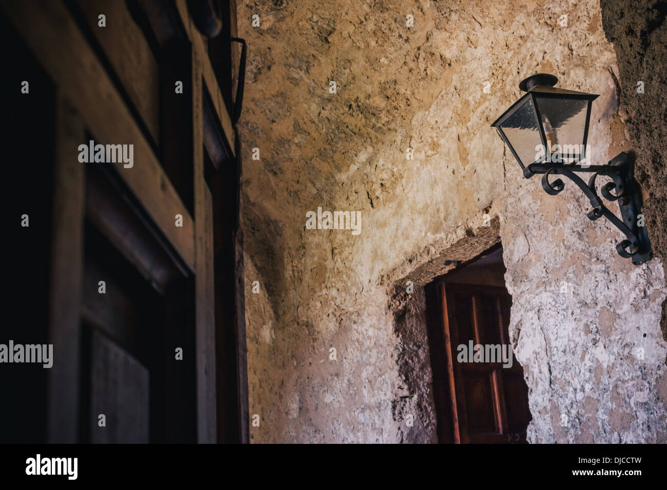 Portale che conduce al colonnato con lanterna in parete a Mission Concepcion, San Antonio, Texas. Foto Stock