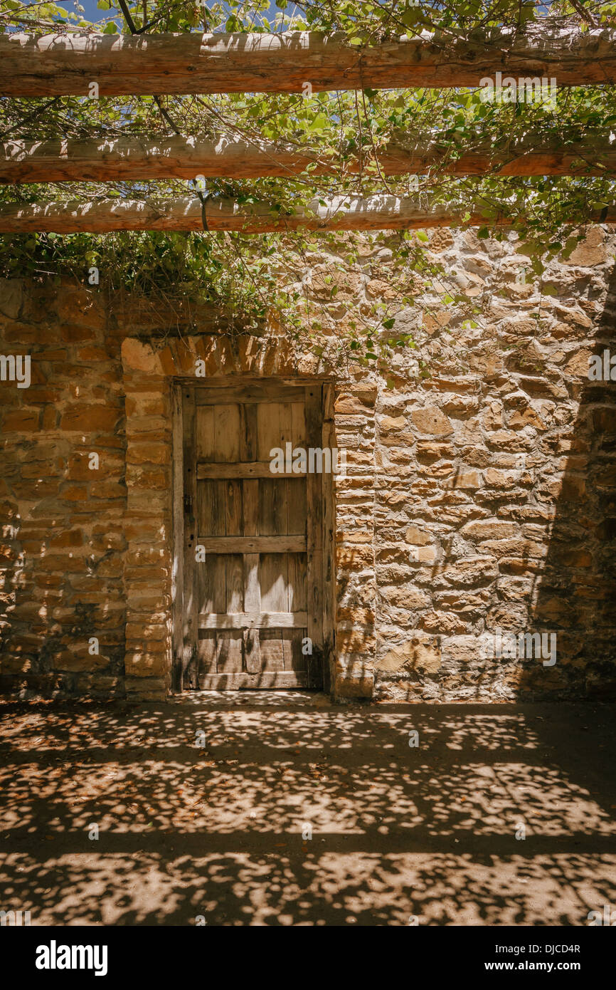 I pergolati in legno con vegetazione gettando ombre in un cortile presso la missione di San Jose. San Antonio, Texas. Foto Stock