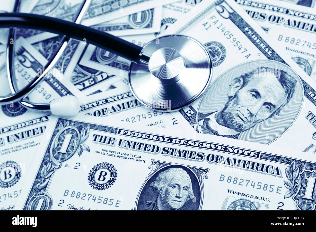 Uno stetoscopio in assortiti banconote americane. Costi di assistenza sanitaria Foto Stock