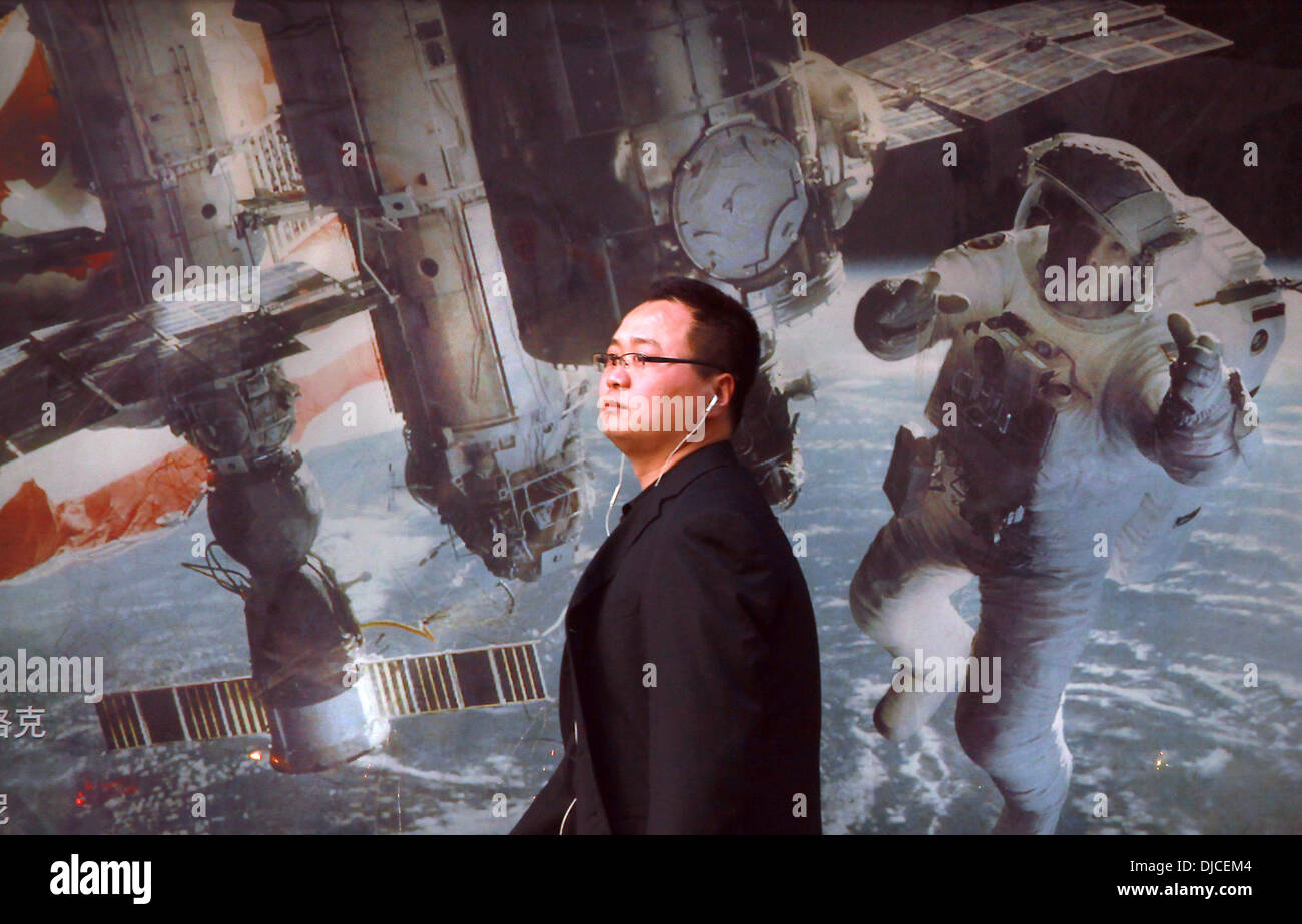 Nov. 24, 2013 - un uomo cinese attende un autobus di fronte un marciapiede pubblicità per un filmato di circa astronauti americani e la stazione spaziale internazionale a Pechino il 24 novembre 2013. La Cina ha la possibilità nel prossimo decennio per superare gli Stati Uniti nello spazio programmi, costringendo il governo degli Stati Uniti per intensificare il finanziamento della NASA per mantenere la sua posizione di leadership, entrare in partnership con il Cinese o rischiare di cadere dietro la politica spaziale dicono gli esperti. (Credito Immagine: © Stephen rasoio/ZUMAPRESS.com) Foto Stock