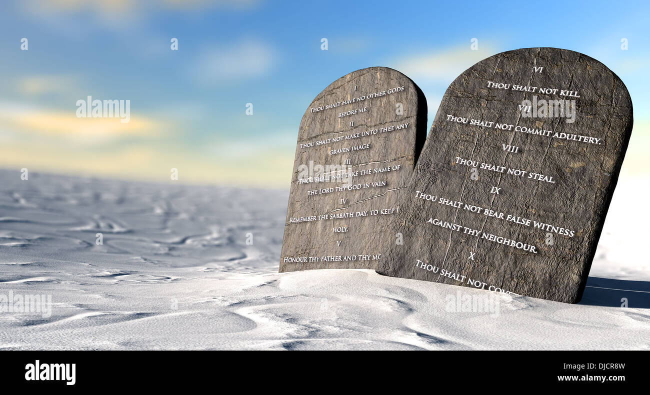 Due tavolette di pietra con i dieci comandamenti incisi su di loro in piedi in marrone sabbia del deserto di fronte un cielo blu Foto Stock