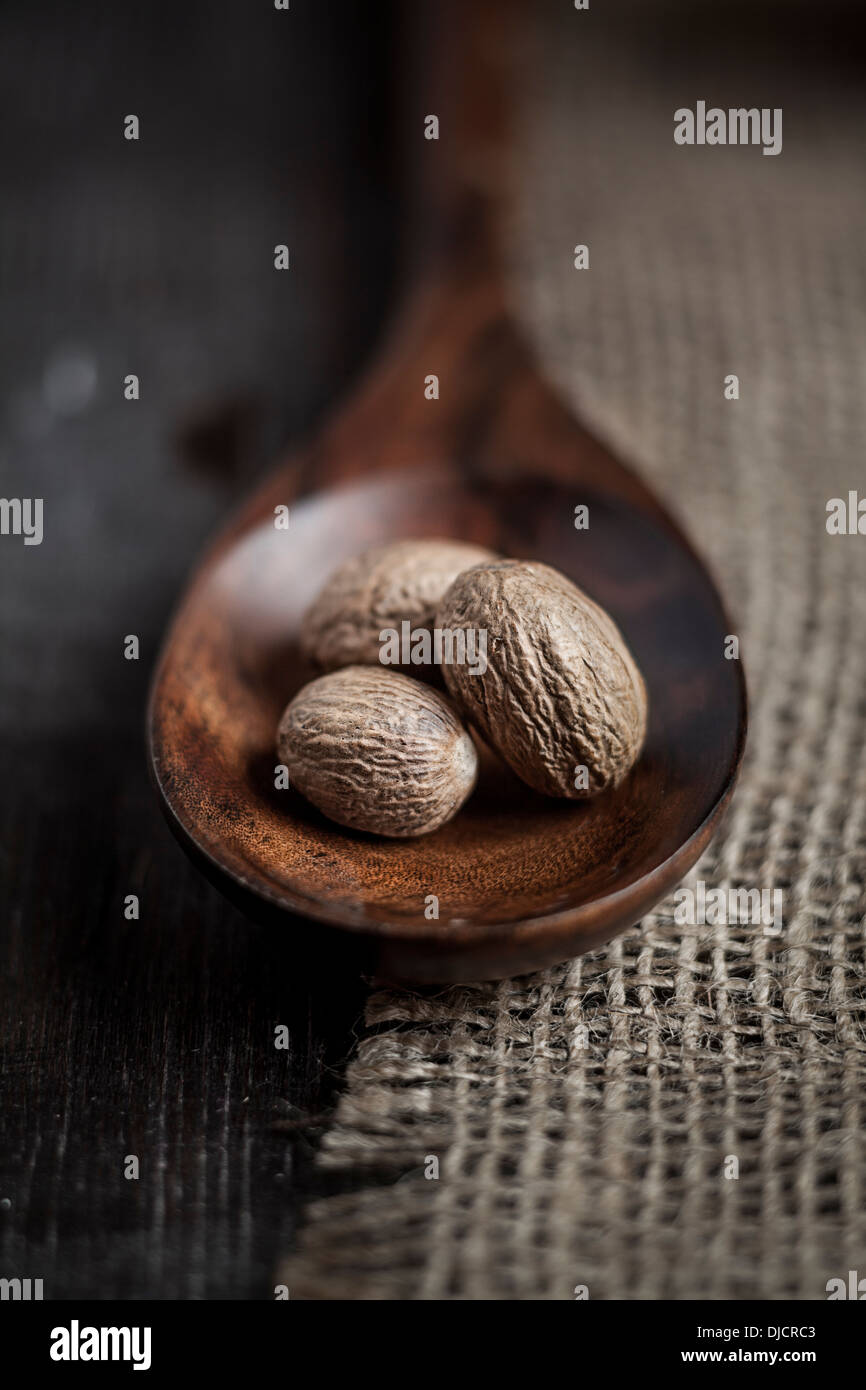 Tre noce moscata sul cucchiaio di legno su tela, studio shot Foto Stock