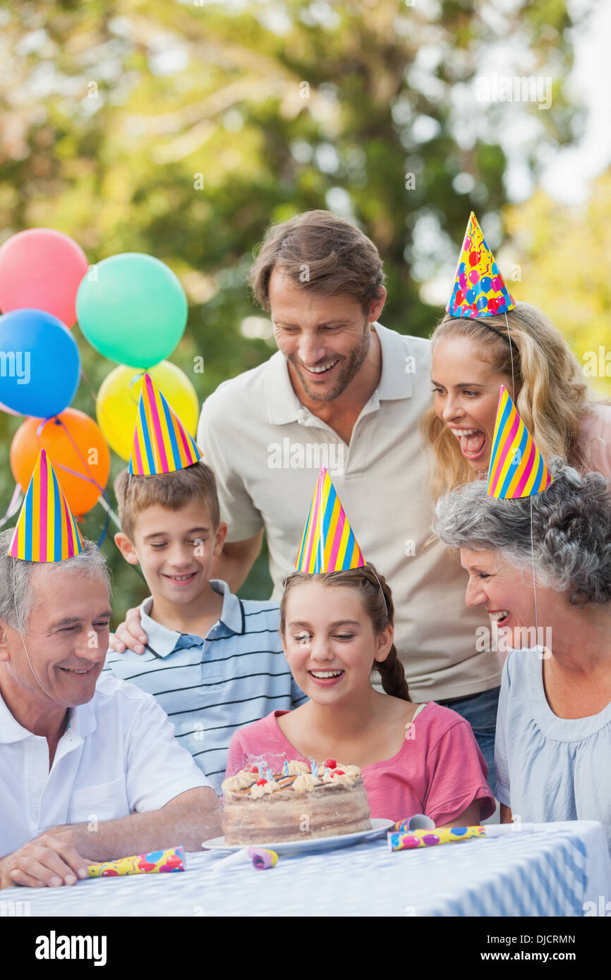 Famiglia allegra indossando party hat mentre festeggia il compleanno Foto Stock