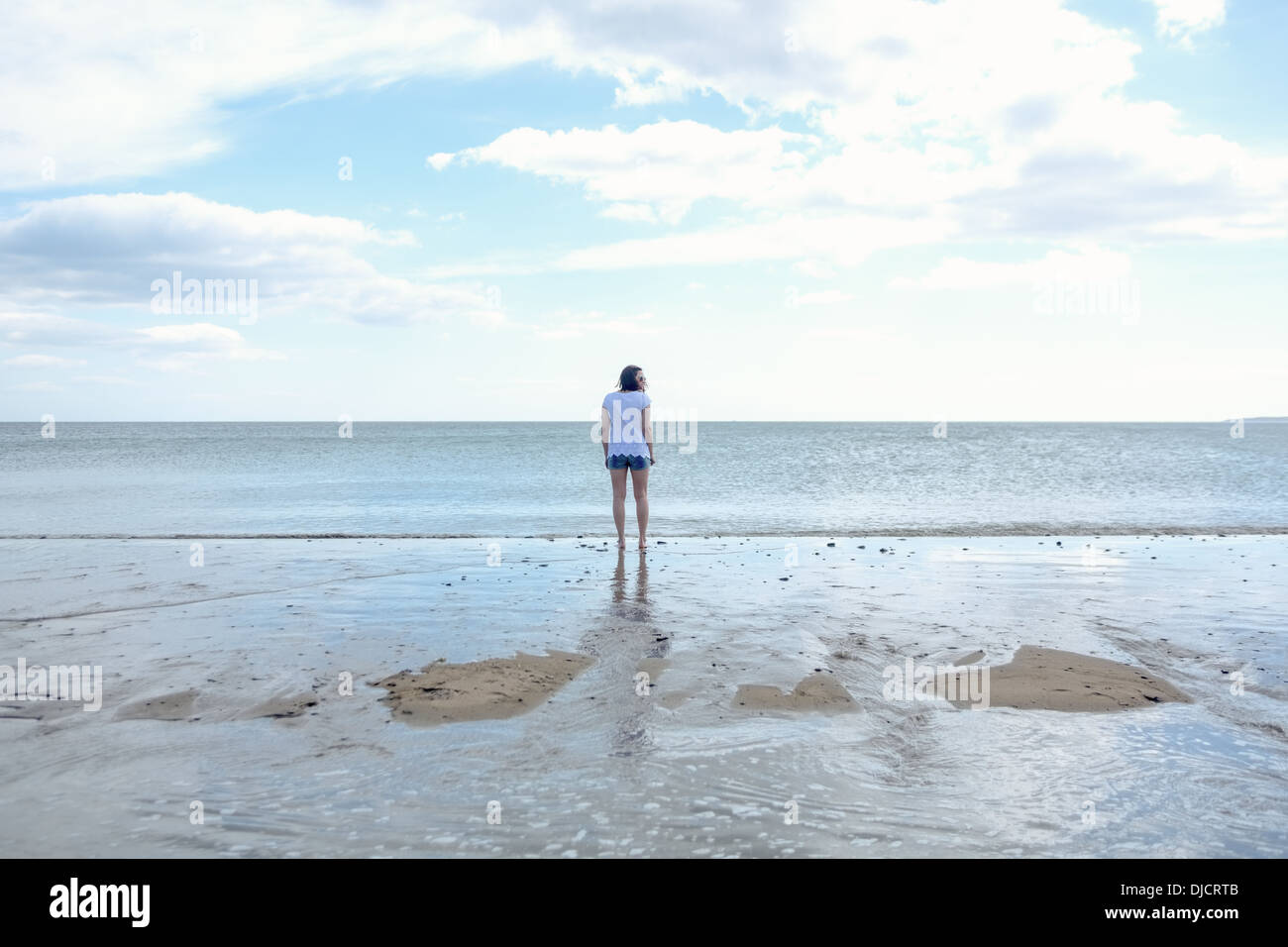 Donna in pantaloncini corti passeggiare al mare Foto Stock