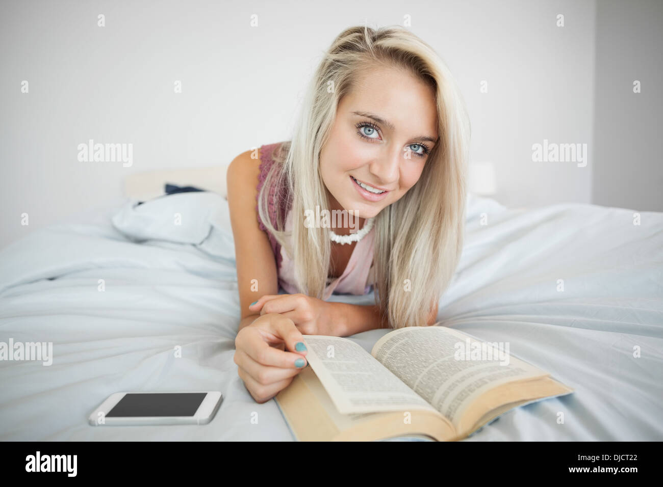 Splendida bionda gleeful la lettura di un libro Foto Stock