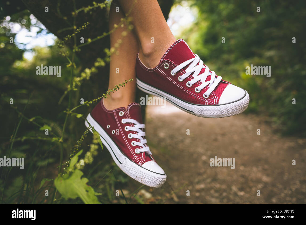 Chiusura del piede femminile di indossare scarpe da ginnastica rosse Foto Stock