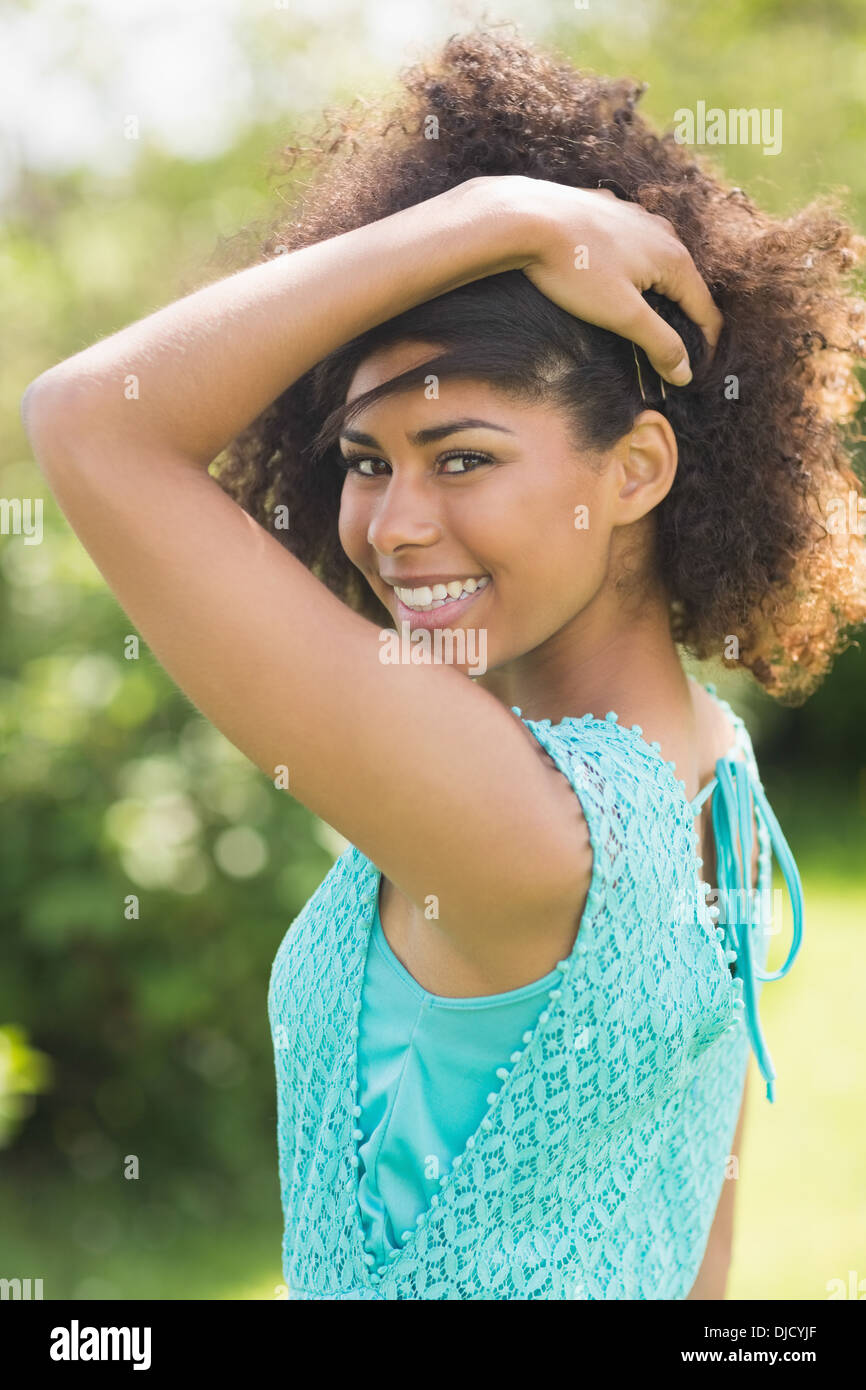 Gorgeous Brunette sorridente guardando sopra la spalla in telecamera Foto Stock
