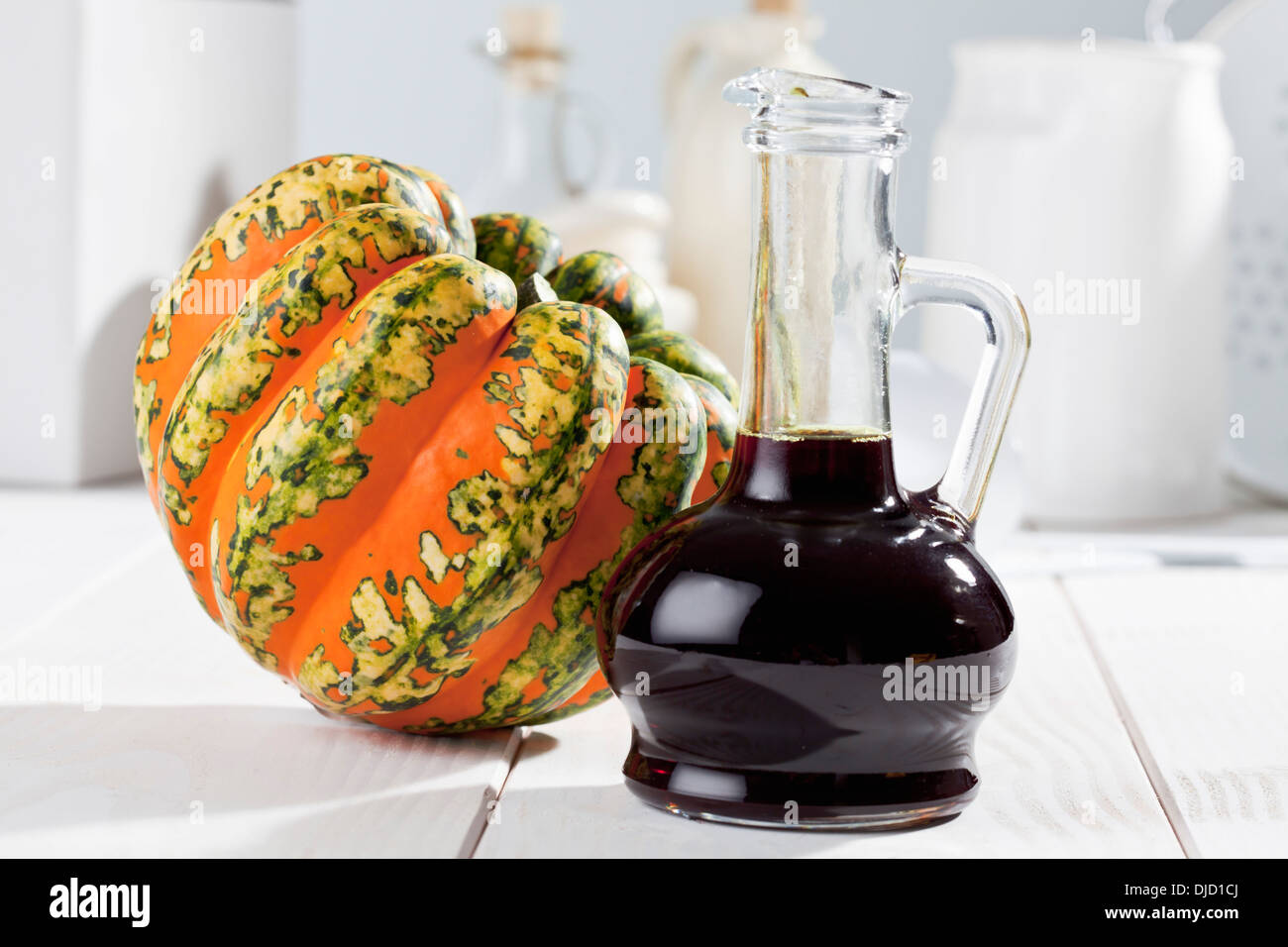 Multicolore di squash (Cucurbita maxima) e la caraffa con olio di semi di zucca studio shot Foto Stock