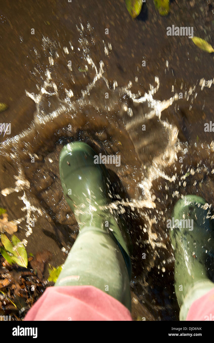 Gli spruzzi di scarponi in pozze fangose di acqua Foto Stock