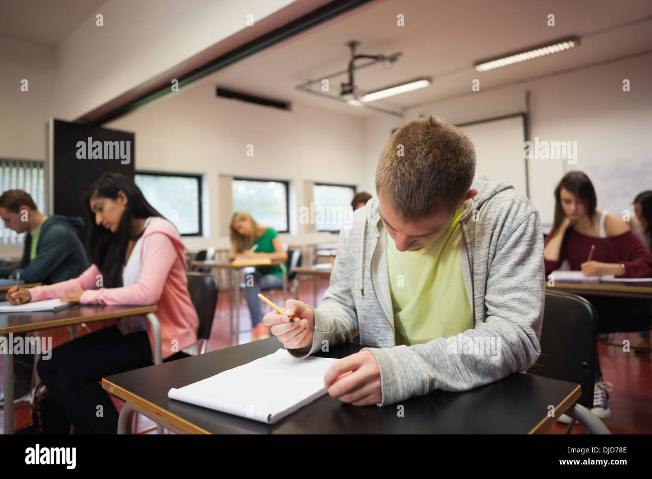 Studenti concentrati tenendo un test in classe Foto Stock