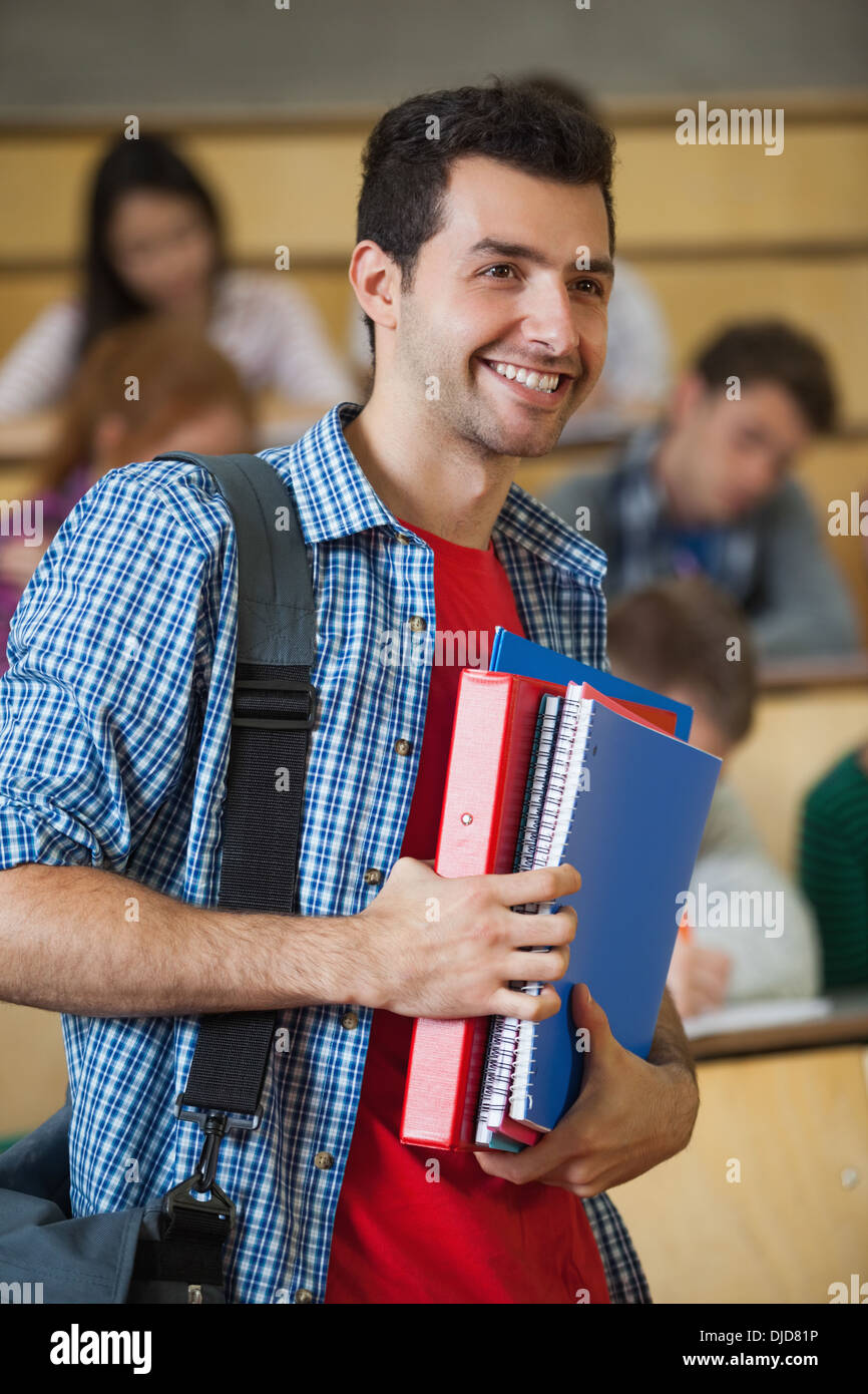Felice studente in piedi nella parte anteriore della sua classe in aula magna Foto Stock