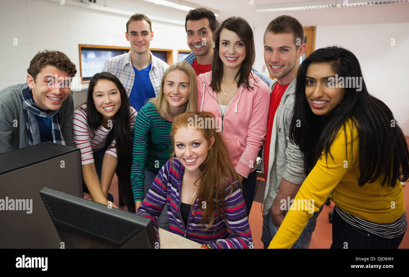 Allievi felici permanente al computer nella sala computer Foto Stock