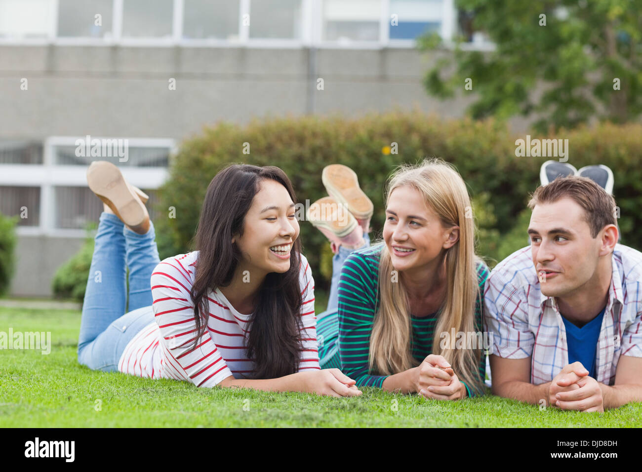 Felice giovani studenti sdraiati sull'erba del campus Foto Stock