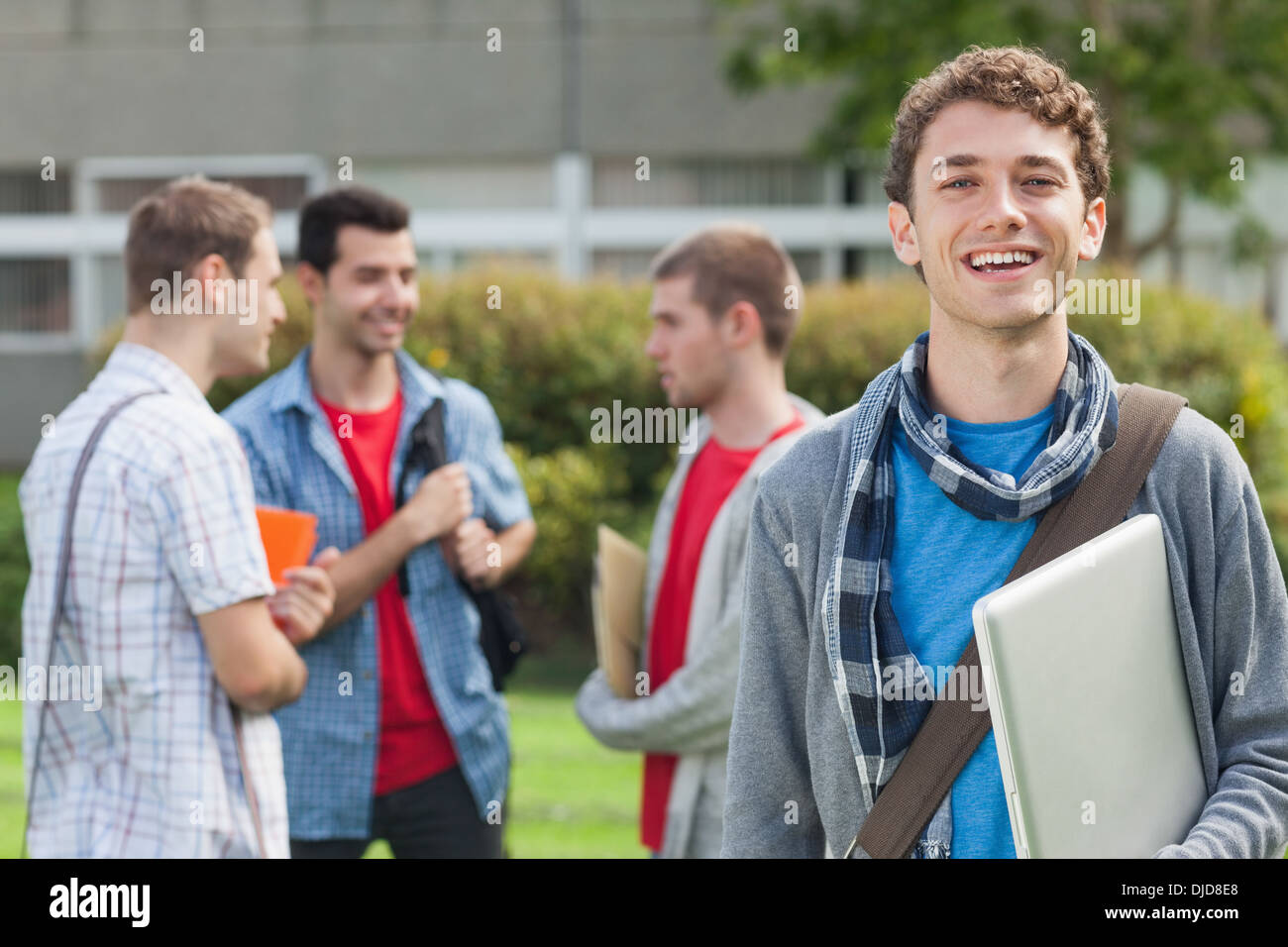 Allegro studente sorridente alla fotocamera nella parte anteriore dei suoi compagni di classe Foto Stock