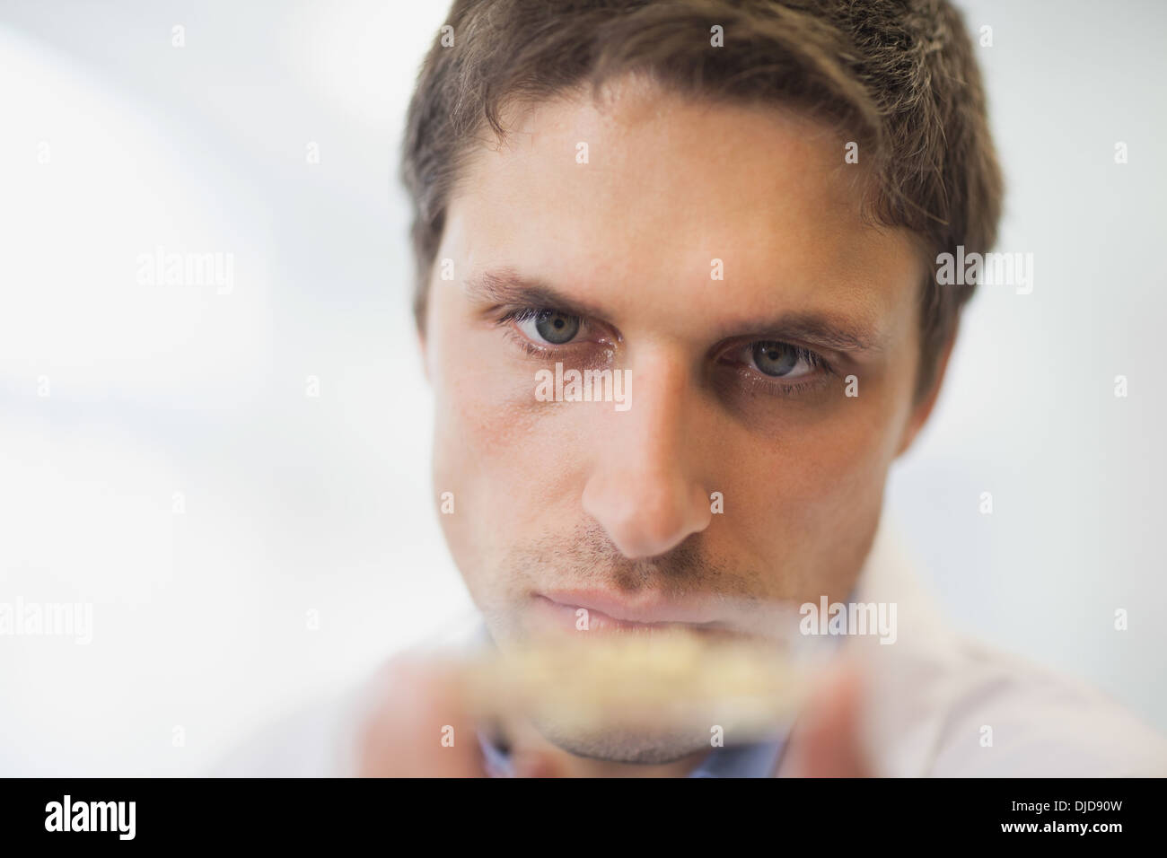 Bel giovane scienziato tenendo una capsula di petri Foto Stock