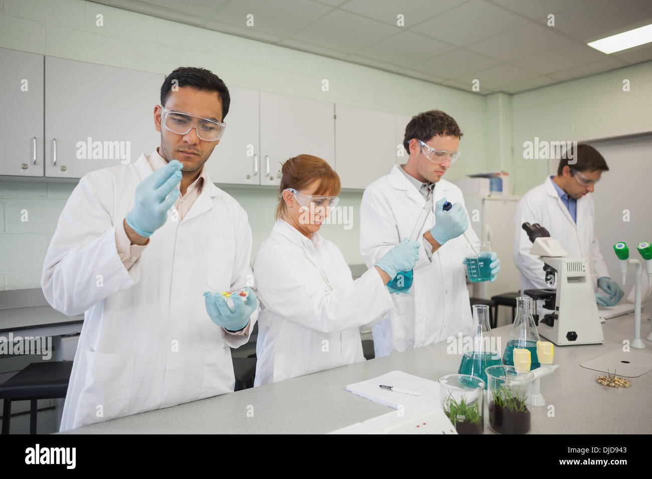 Gli scienziati in piedi in una fila mentre si lavora Foto Stock