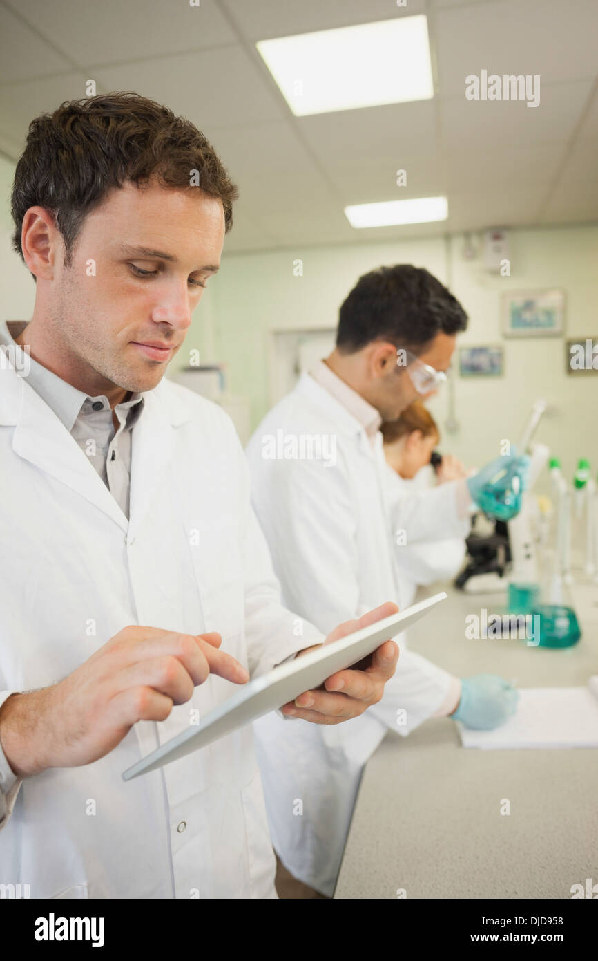 Carino giovane scienziato utilizzando il suo tablet Foto Stock