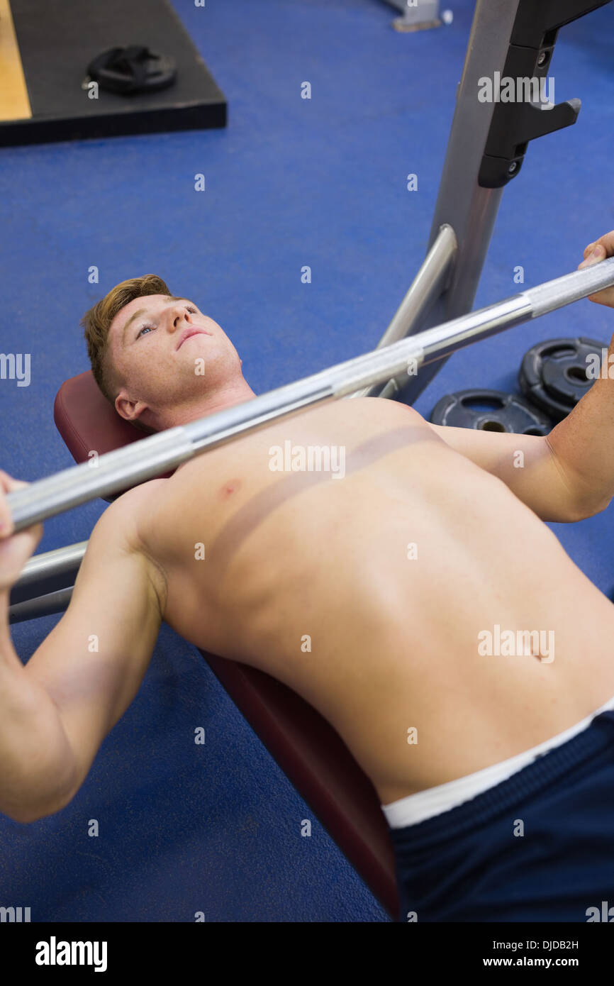 Buona ricerca muscolare di uomo disteso su di sollevamento del banco barbell Foto Stock