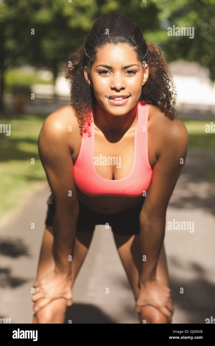 Stanco donna sana prendendo una pausa durante il jogging nel parco Foto Stock