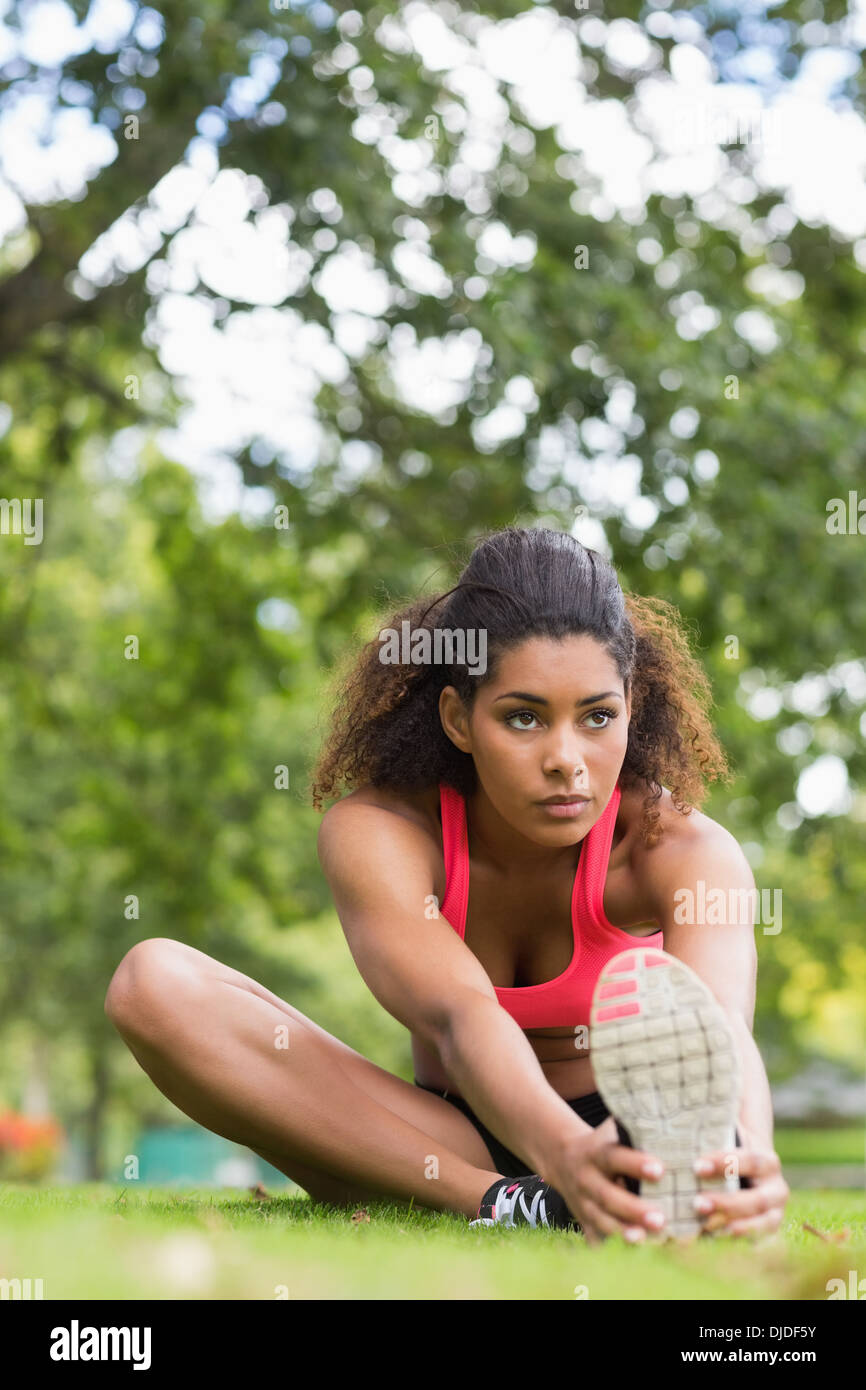 Bella donna sportiva stretching la gamba in posizione di parcheggio Foto Stock
