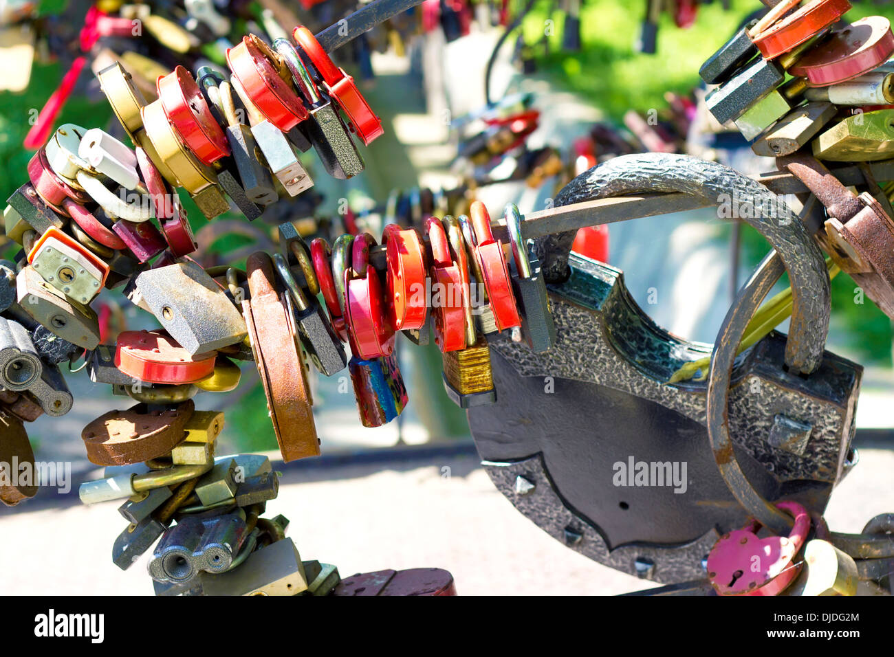 Molti diversi lucchetti colorati appesi in una riga Foto Stock
