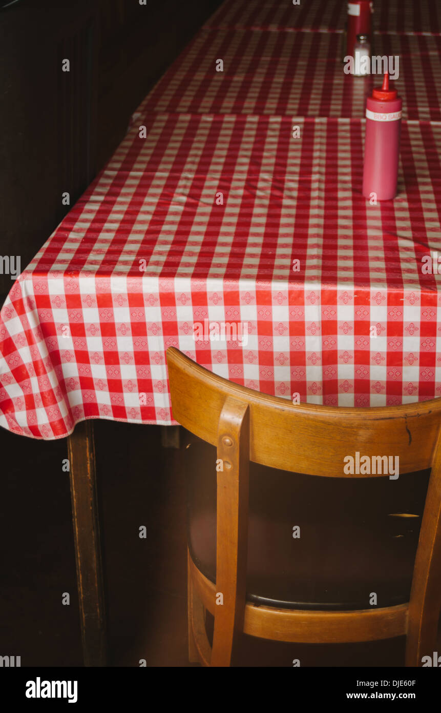 Iconico rosso e bianco tavola a scacchi la copertura di tessuto la tabella di un barbecue comune di lungo la route 281 nel cuore del Texas Hill Country. Foto Stock