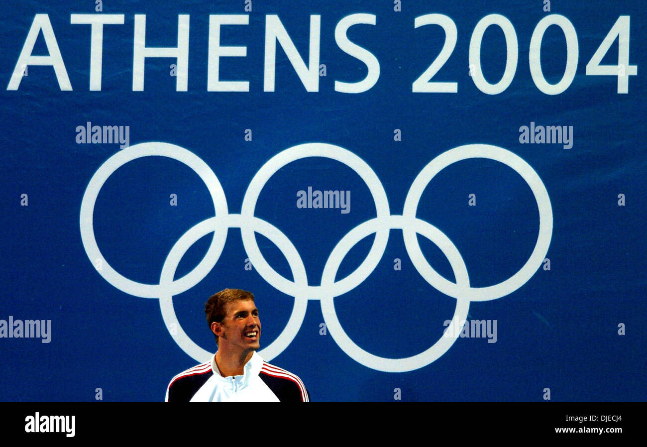 Agosto 20, 2004; Atene, Grecia; U. S. nuotatore olimpico Michael Phelps sorride alla folla Venerdì 20 Agosto, 2004 ad Atene, Grecia durante l'attesa per la 100 metri farfalla Medal Ceremony per iniziare. Phelps ha vinto l'oro in caso con un tempo di 51.25 secondi stabilendo un nuovo record olimpico. Foto Stock