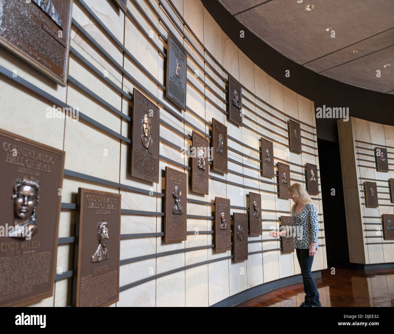 Una donna guarda le lapidi dedicate alla musica country stelle su una parete interna del Country Music Hall of Fame a Nashville, TN. Foto Stock