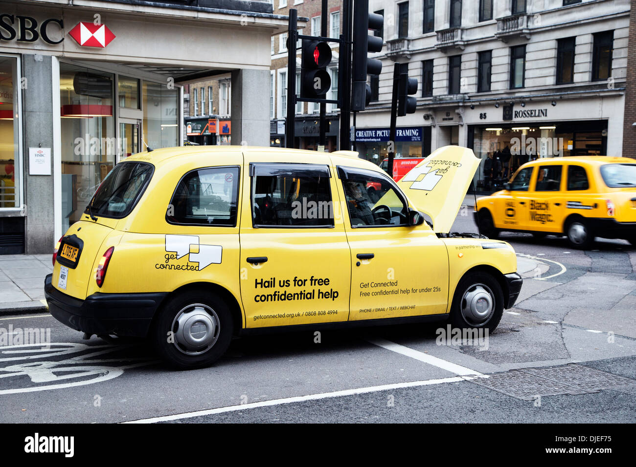 Brutta giornata in ufficio. Yellow Cab Londra tasse,ho ripartiti al semaforo, occupato di giunzione a Baker Street, Londra Inghilterra, Regno Unito Foto Stock