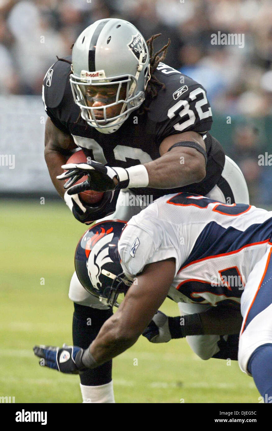 Oct 17, 2004; Oakland, CA, Stati Uniti d'America; NFL Football: #32 Zack Crockett viene affrontato su un guadagno di breve da #52 D.J. Williams nel primo trimestre. Foto scattata durante i raider vs Broncos gioco presso la Network Associates Coliseum. Foto Stock