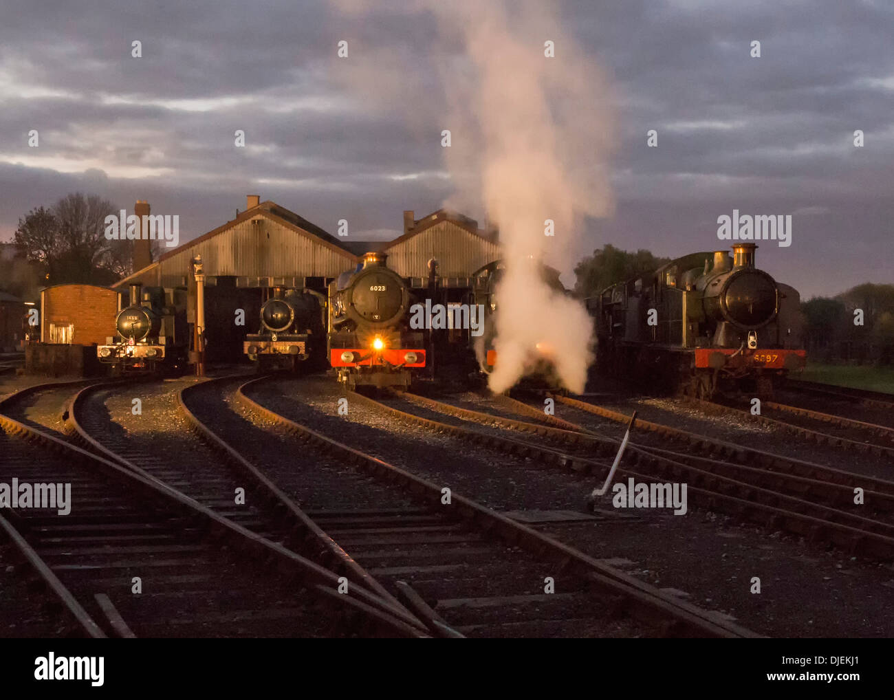 GWR conserve di locomotive a vapore 6023 'King Edward II', 43xx classe 2-6-0 5322 & Collett Classe 5600 0-6-2T 6697 su un capannone di notte Foto Stock