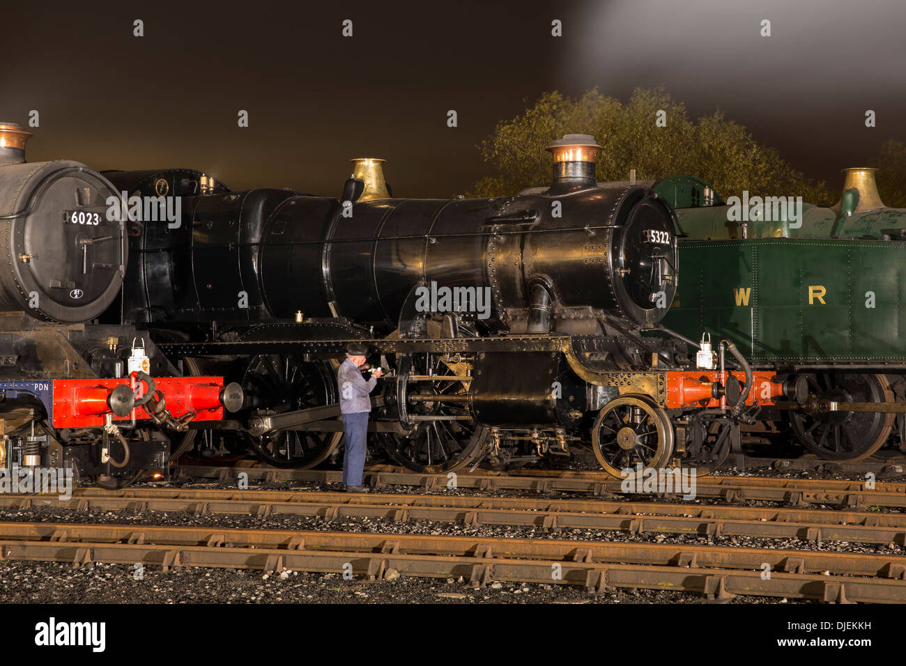 GWR conserve di locomotive a vapore 6023 'King Edward II', 43xx classe 2-6-0 5322 & Collett Classe 5600 0-6-2T 6697 su un capannone di notte Foto Stock