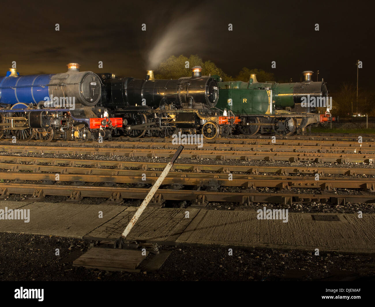 GWR conserve di locomotive a vapore 6023 'King Edward II', 43xx classe 2-6-0 5322 & Collett Classe 5600 0-6-2T 6697 su un capannone di notte Foto Stock