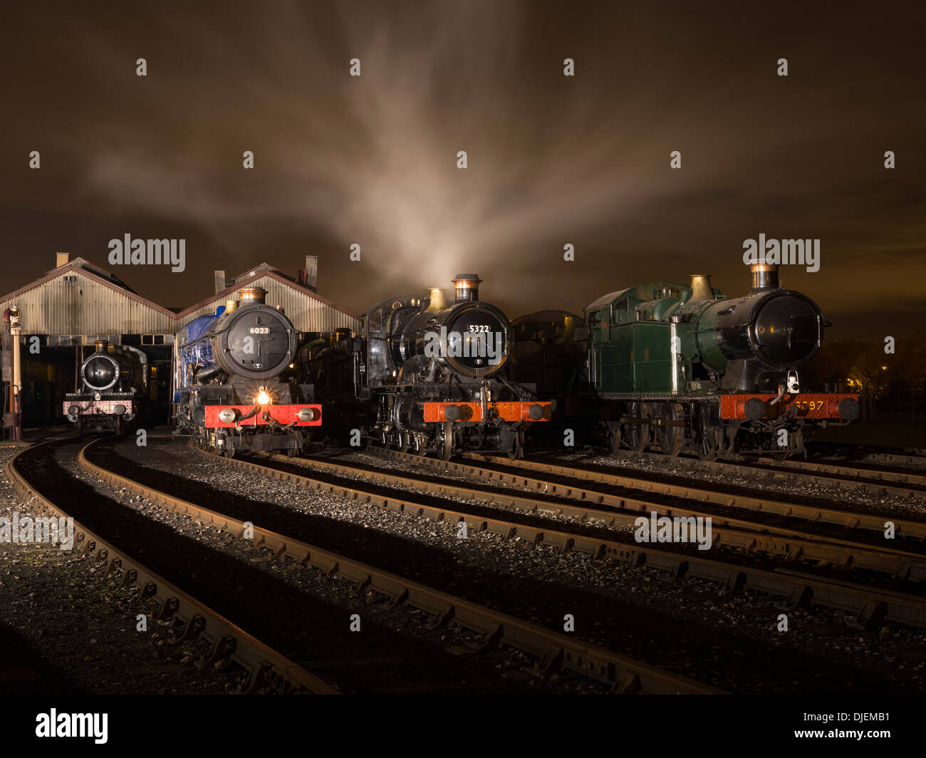 GWR conserve di locomotive a vapore 6023 'King Edward II', 43xx classe 2-6-0 5322 & Collett Classe 5600 0-6-2T 6697 su un capannone di notte Foto Stock