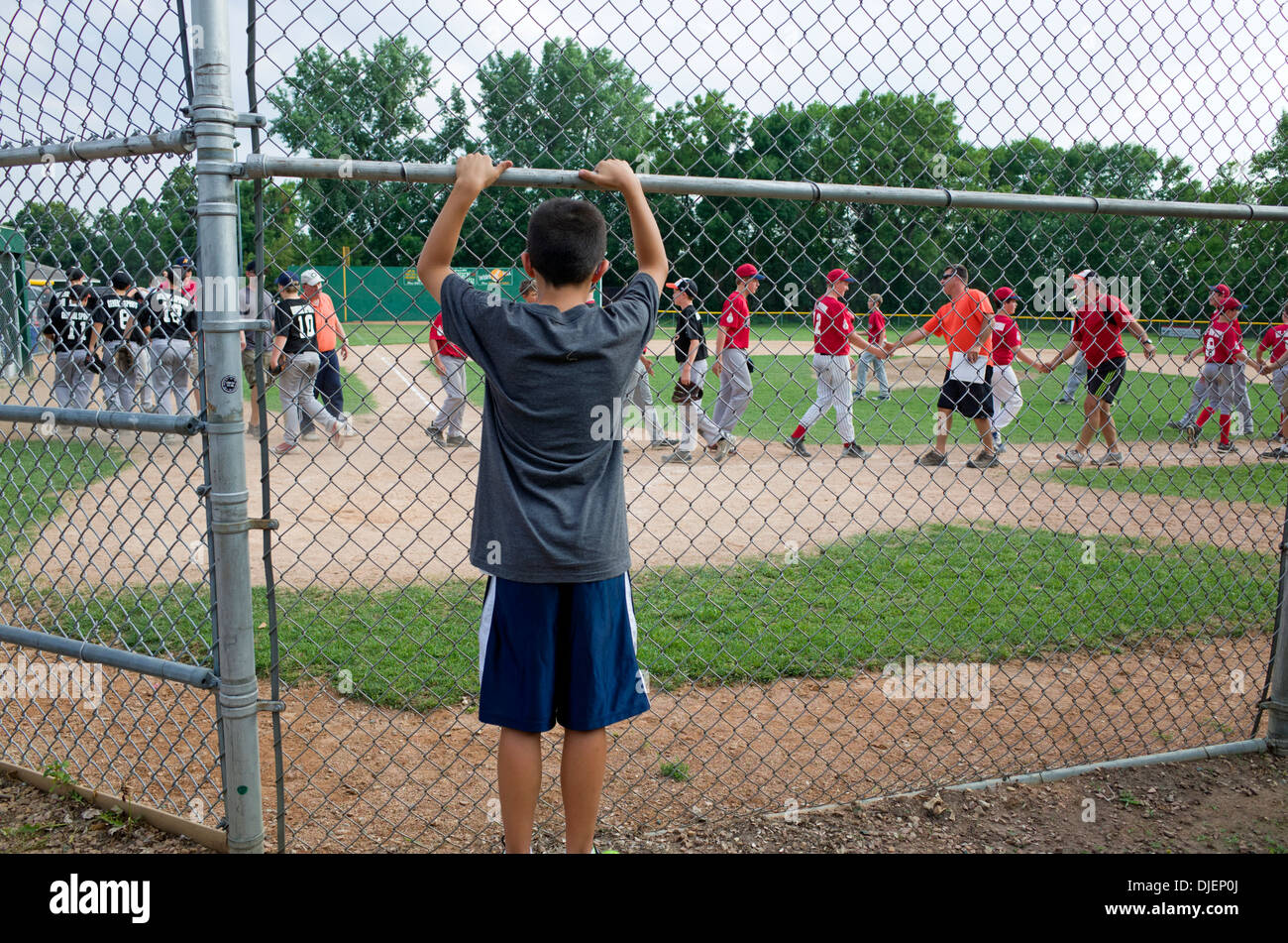 Young Teen boy guarda la squadra di baseball buone pratiche di sportività agitando mani dopo il gioco. St Paul Minnesota MN USA Foto Stock