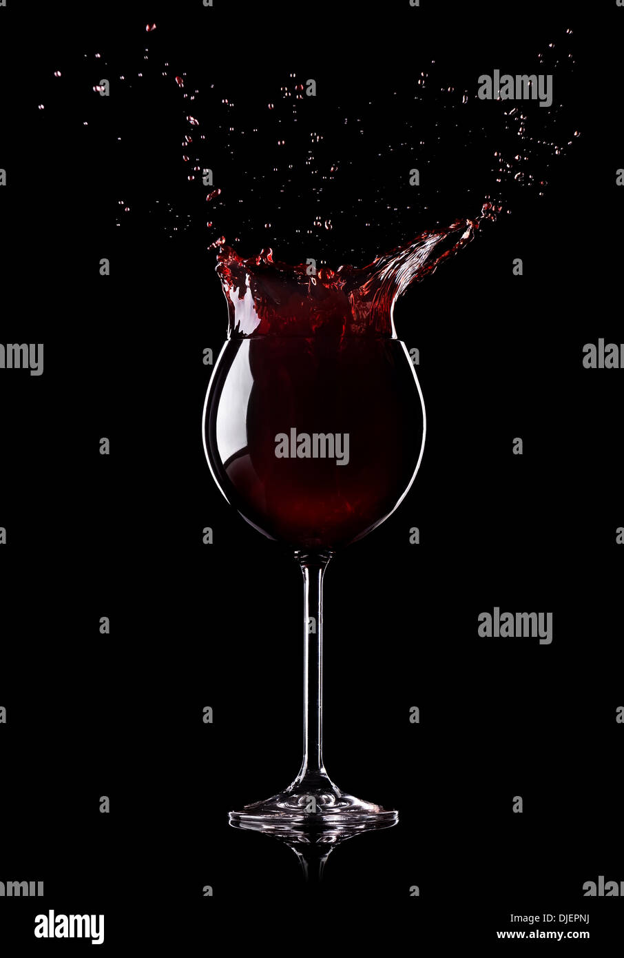 Spruzzi di vino da un vino-vetro su sfondo nero Foto Stock