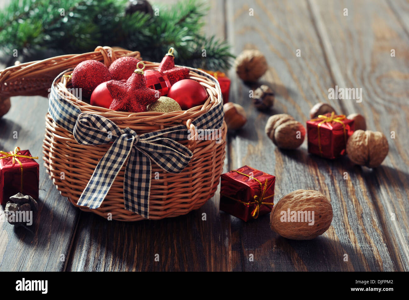 Le decorazioni di Natale nel cesto di vimini e abete su sfondo di legno Foto Stock