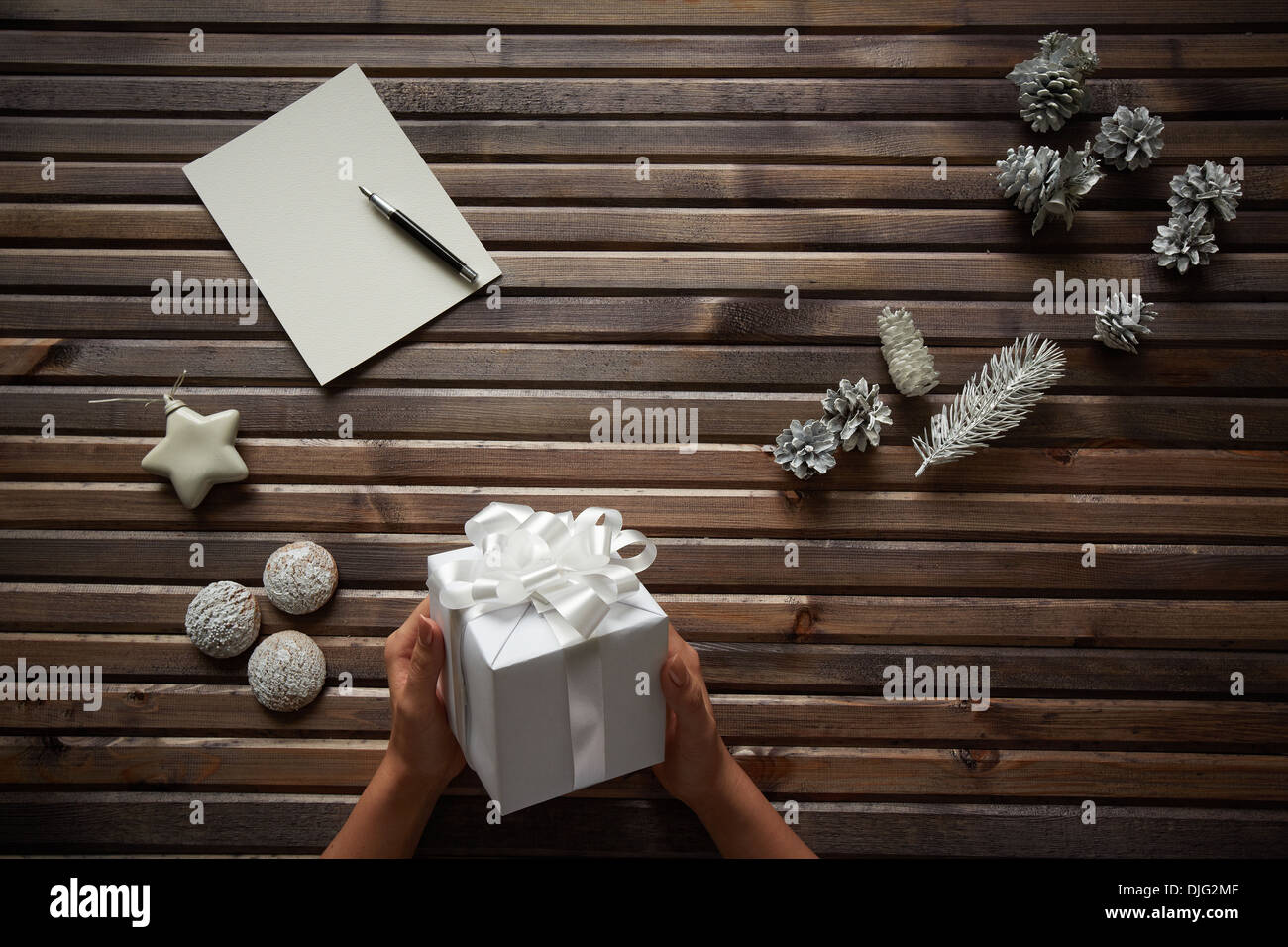 Immagine di tre spezie dolci, decorativo coni d'argento, con carta e penna giocattolo bianco stella femmina circostante mani giftbox Foto Stock