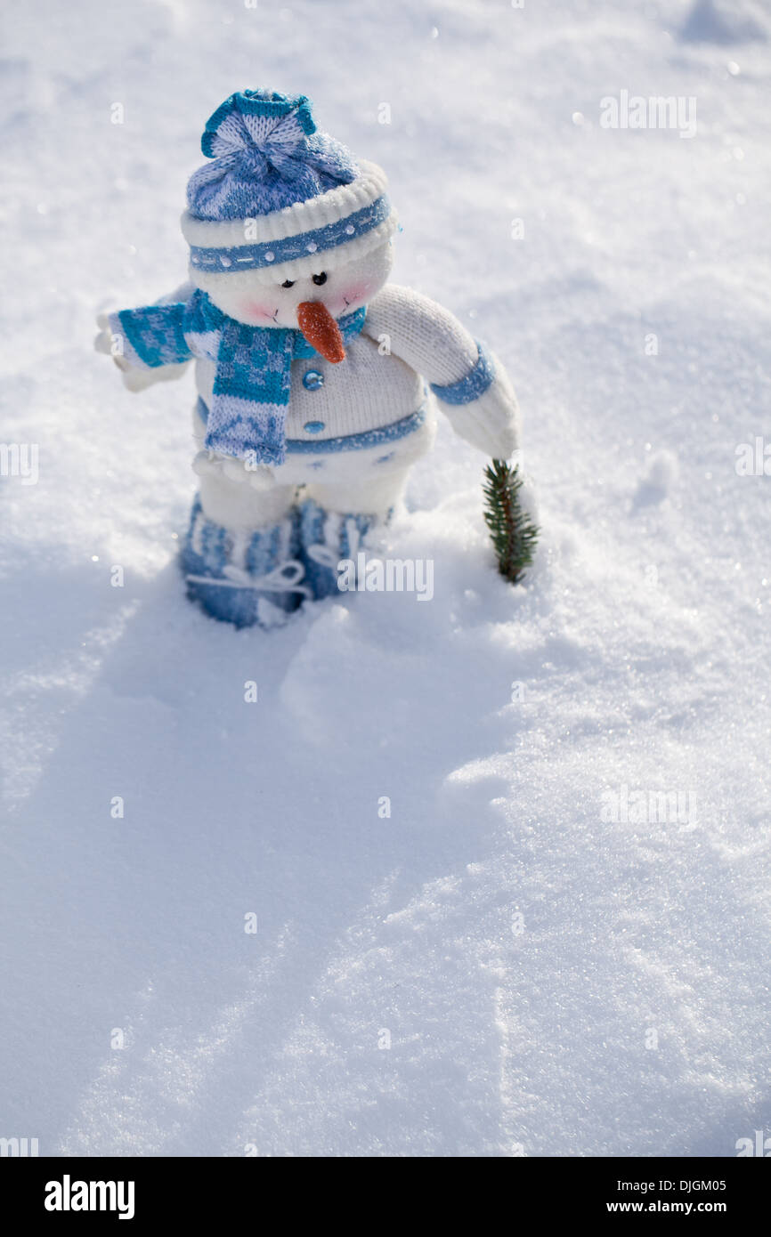 Poco pupazzo di neve con la carota naso nella neve. Foto Stock