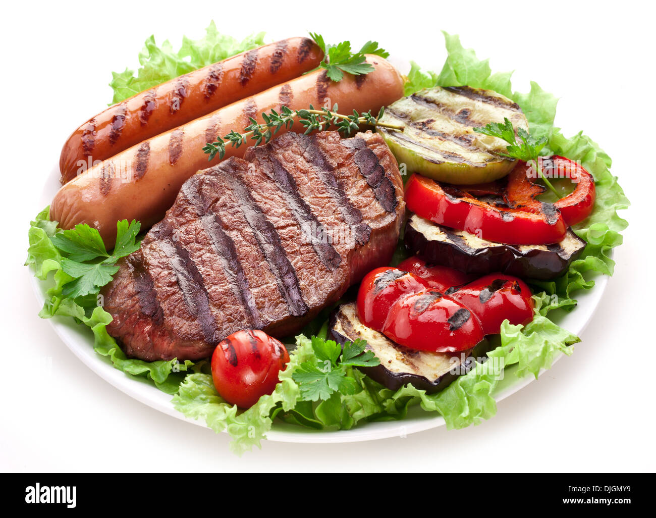 Bistecca alla griglia,salsicce e verdure sopra le foglie di lattuga. Foto Stock