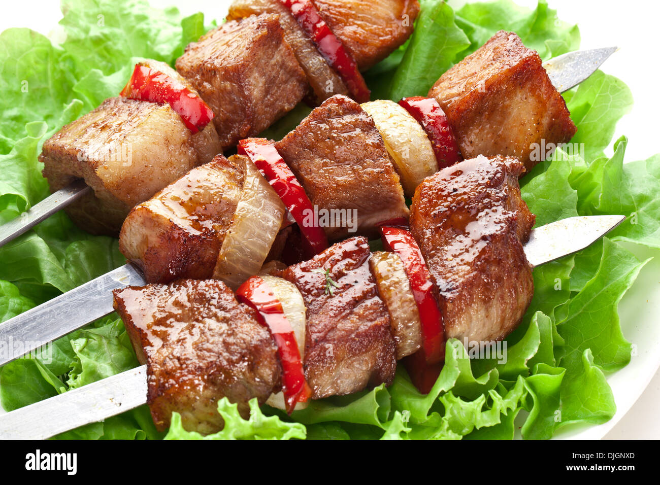 Kebab alla griglia (spiedini) su sputa su foglie di lattuga. Foto Stock