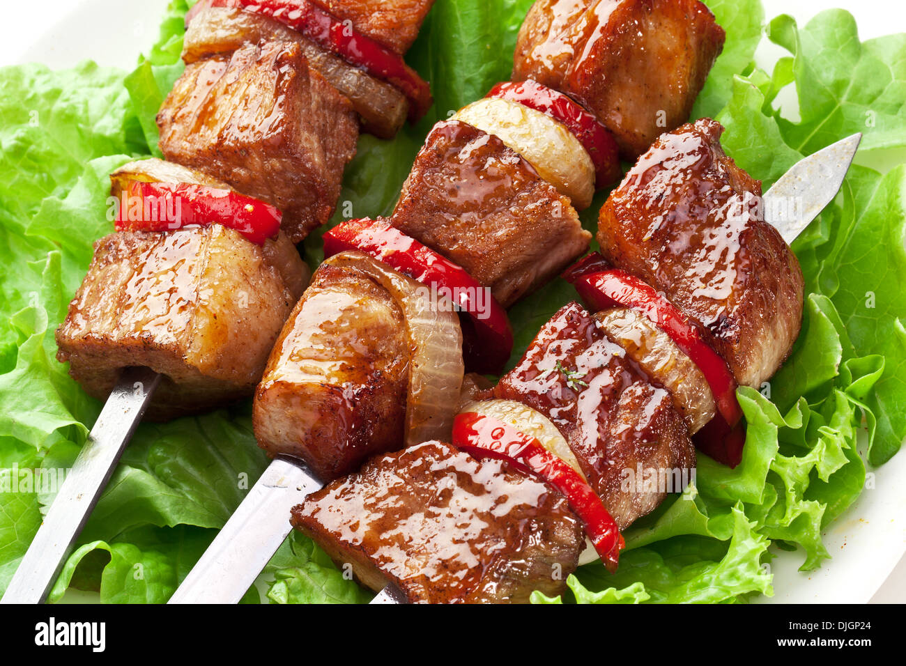 Kebab alla griglia (spiedini) su sputa su foglie di lattuga. Foto Stock