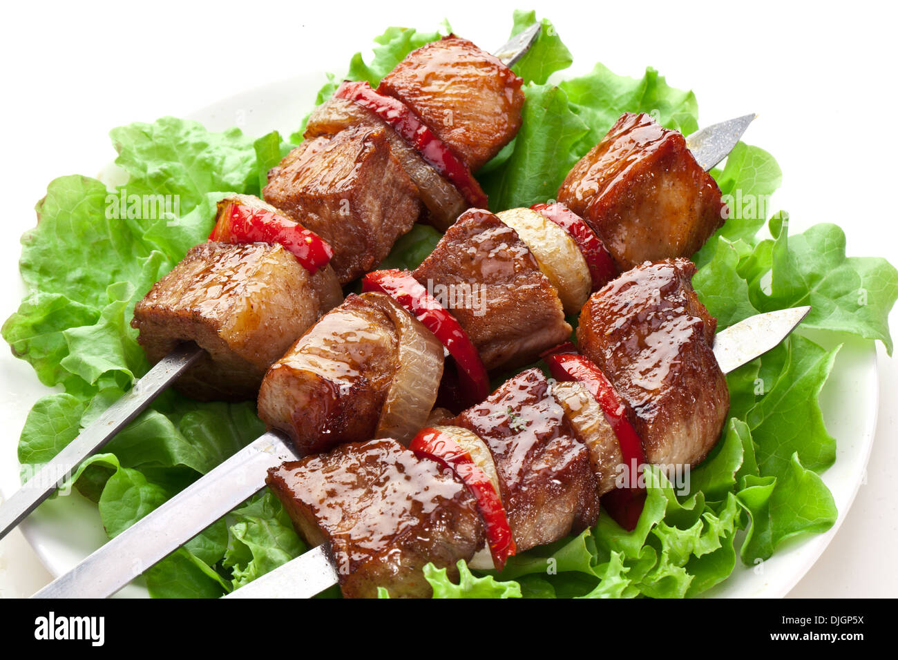 Kebab alla griglia (spiedini) su sputa su foglie di lattuga. Foto Stock