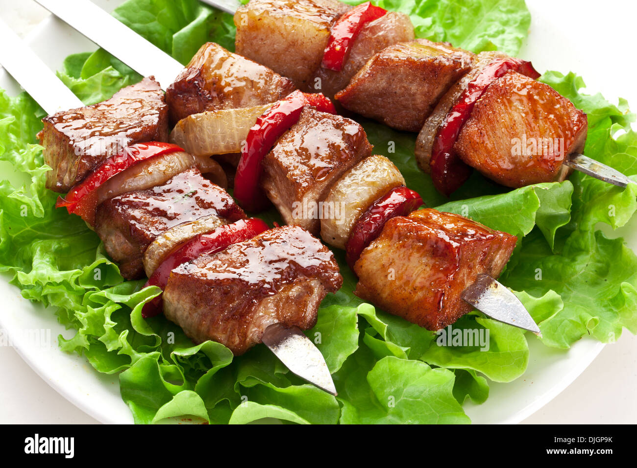 Kebab alla griglia (spiedini) su sputa su foglie di lattuga. Foto Stock