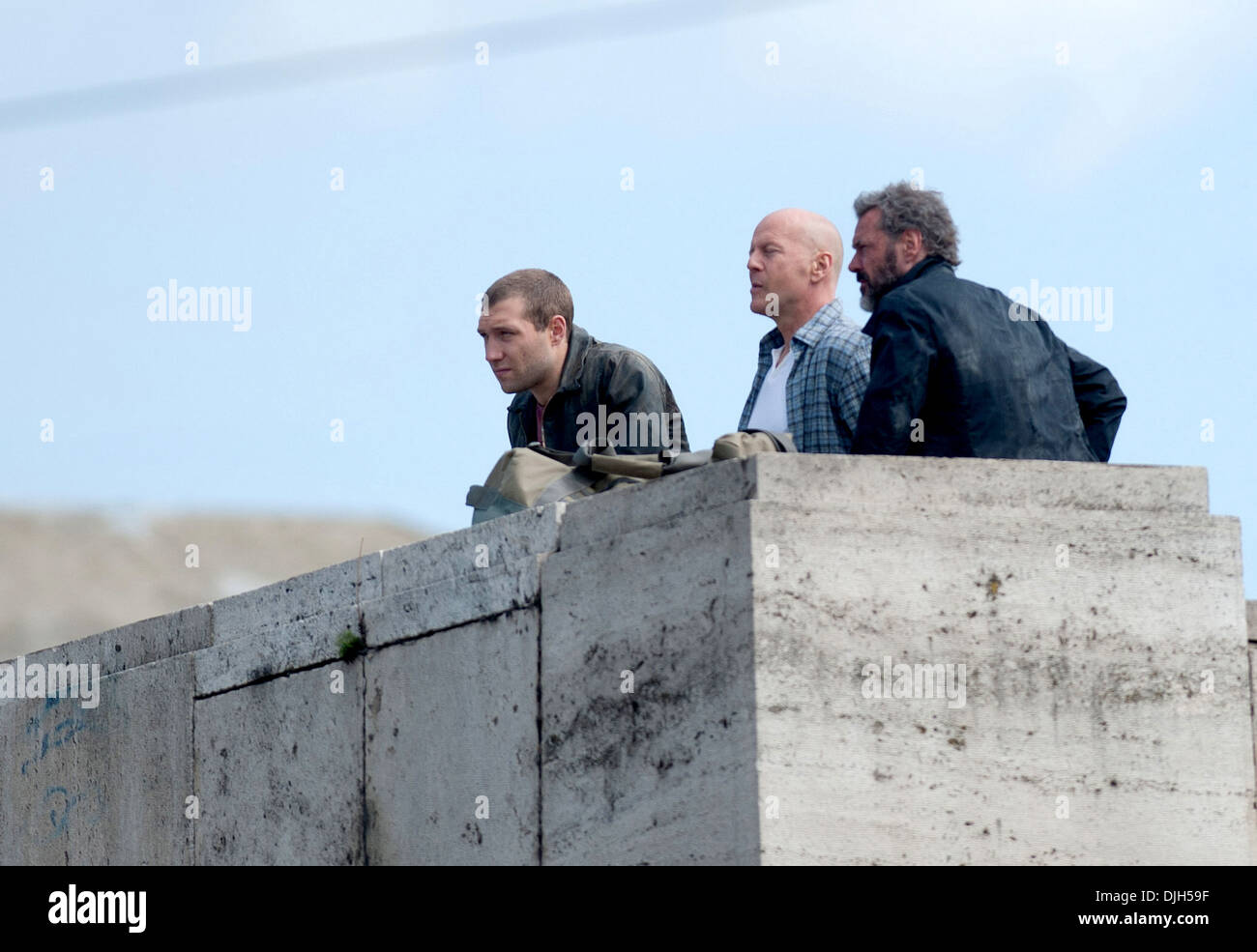 Jai Courtney Bruce Willis e Sebastian Koch le riprese di una scena sul set di un film di un "Buon giorno a Die Hard' Ungheria Budapest - Foto Stock