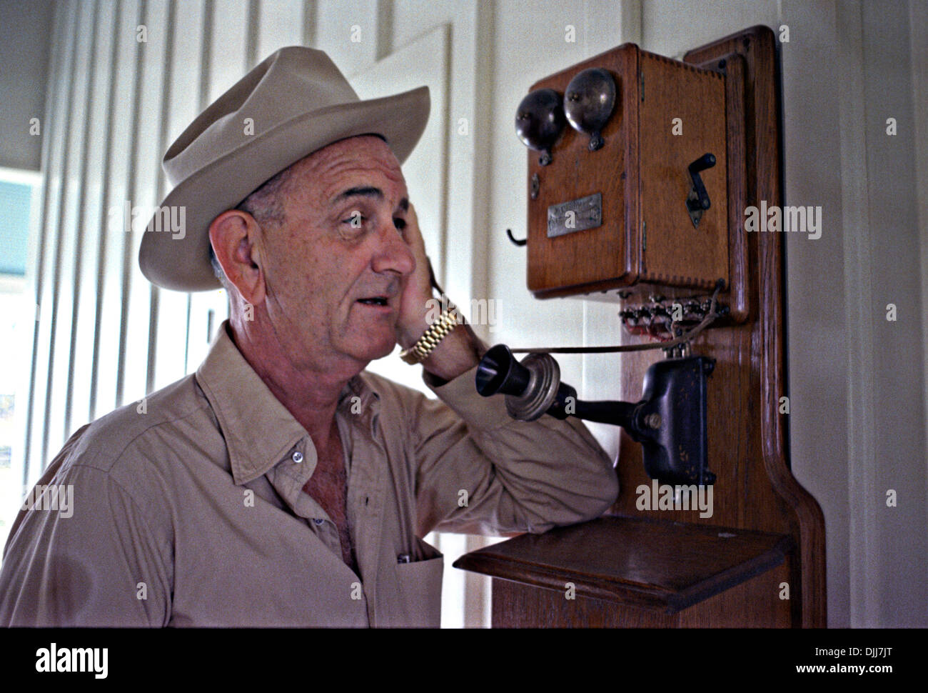 Il presidente statunitense Lyndon B. Johnson in un cappello da cowboy parlando su un antico telefono nel suo ranch Novembre 20, 1965 in Stonewall, Texas. Foto Stock