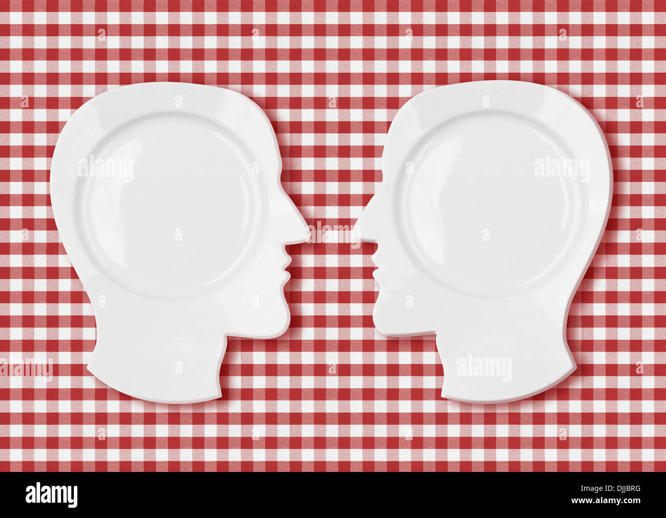 Due piastre di testa faccia a faccia sul rosso tovaglia da picnic Foto Stock