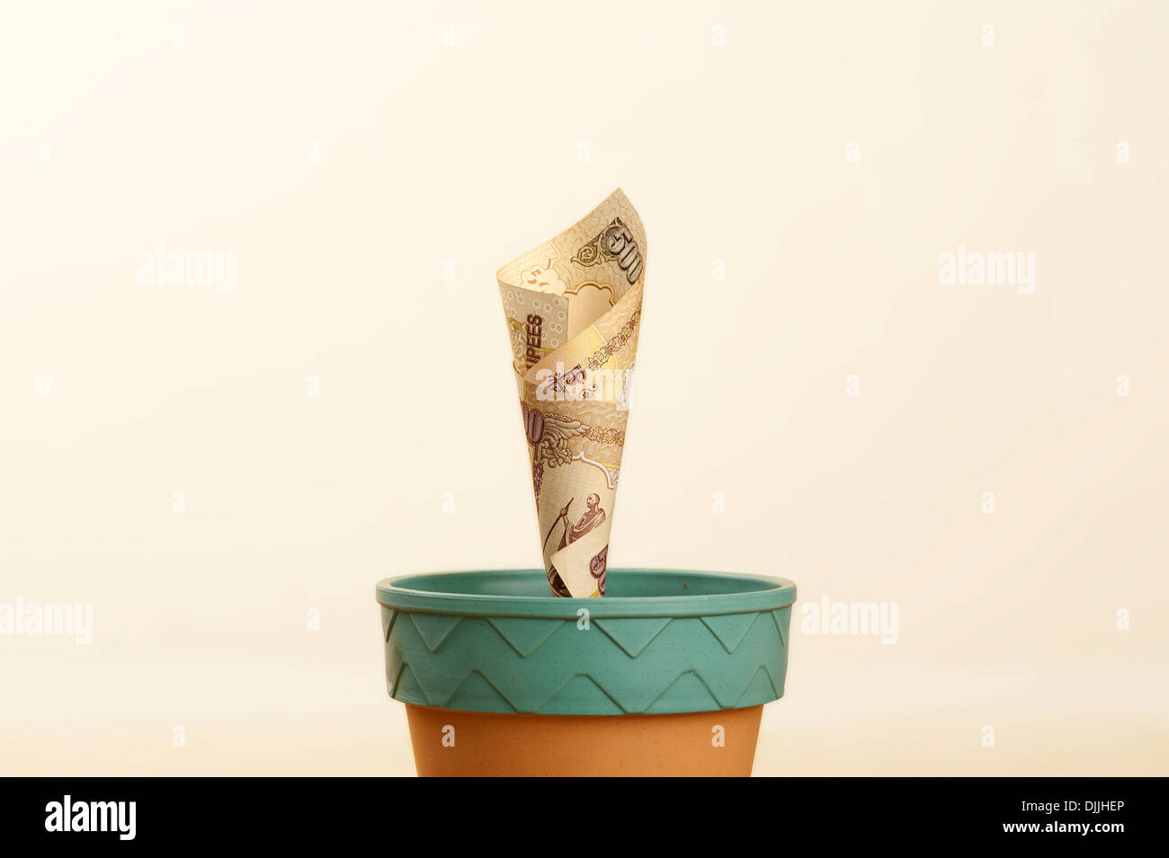 Impianto di denaro - immagine concettuale illustrante il denaro cresce come una pianta in un vaso Foto Stock