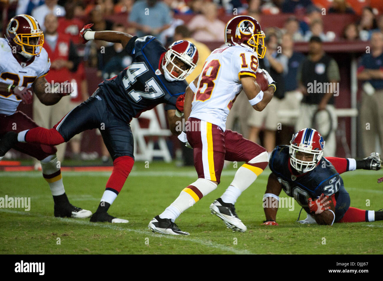 Agosto 13, 2010 - Landover, Maryland, Stati Uniti d'America - 13 August, 2010: Washington Redskins wide receiver TERRENCE AUSTIN (#18) guarda a correre attraverso le fatture della Buffalo difesa con libero di sicurezza CARY HARRIS (#47) e marcia indietro JOIQUE BELL (#35) nel perseguimento di FedEx Campo in Landover, MD..Mandatory Credit: Rassi Borneo / Southcreek globale di credito (Immagine: Â© Southcreek globale/Z Foto Stock